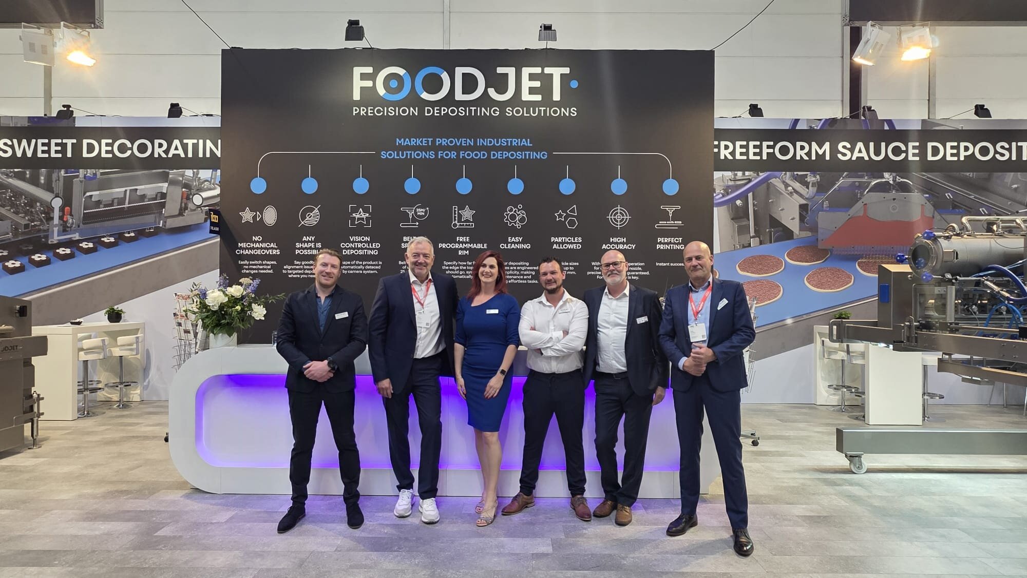 Six members of the FoodJet team in front of the FoodJet trade show stand
