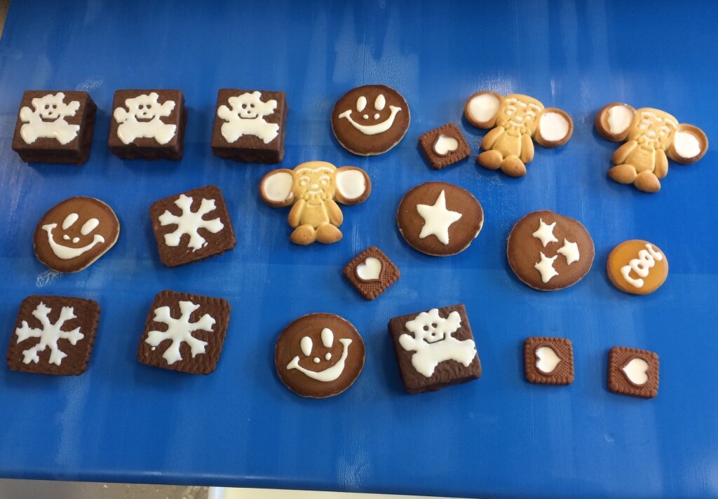 Biscuits with white bears, smileys, snowflakes, stars and hearts on a blue belt