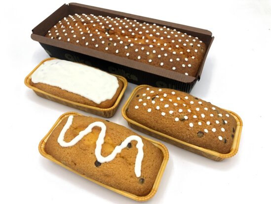 A large loaf cake with white dots and three small loaf cakes with a white layer, white dots and a wave line