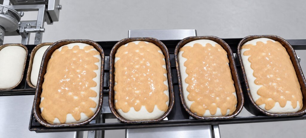 Top view of bread tins with tiger paste on the dough
