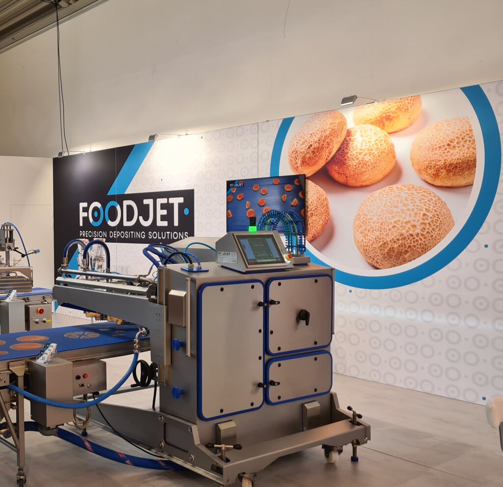 FoodJet stand at iba 2023 in Munich with a depositor and a blue conveyor